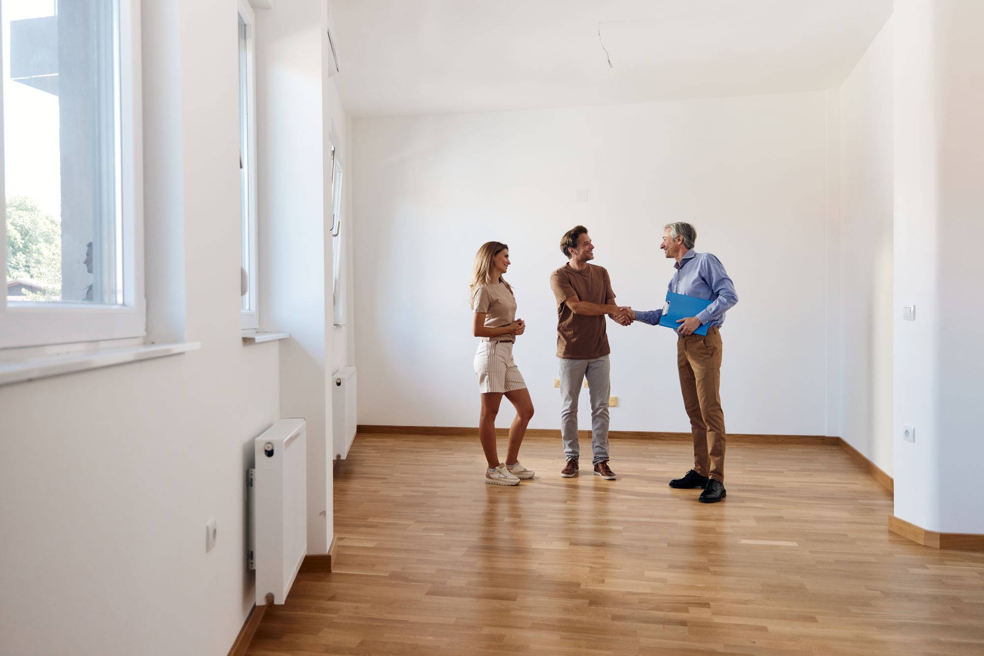 PIA Junges Paar schüttelt die Hand mit Makler